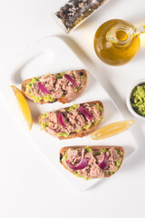 Toast with Canned Tuna. Fish open sandwich with avocado, red onion and lemon. 