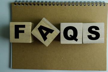 Concept of The wooden Cubes with the word Faqs on wooden background.