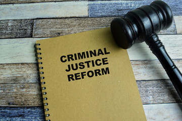 Concept of Criminal Justice Reform write on book with gavel isolated on Wooden Table. - obrazy, fototapety, plakaty