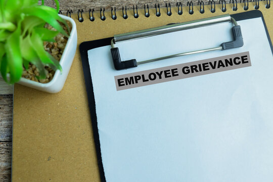 Concept of Employee Grievance write on paperwork isolated on wooden background.