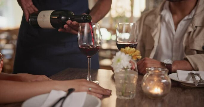 Couple, Restaurant And Waiter Pour Wine On Date For Anniversary Meal, Valentines Day Or Engagement. Hands, Glass And Alcohol Beverage At Table In London Cafe For Happy Celebration, Drink Or Marriage