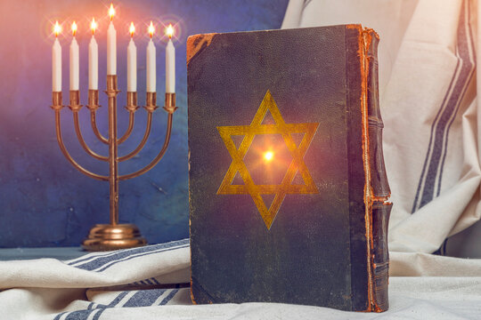 Old book Talmud, Hebrew Rabbinic Judaism, Jewish religious law. Torah, Hebrew Bible. Menorah, Star of David on a dark cover. Holy Scripture, word of God. Antique edition, vintage worn paper