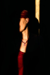 Obraz premium Close-up shot of a middle-aged woman's neck. Necklace with a heart-shaped pendant from rose quartz on the neck. Rays of the setting sun