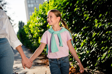 Cropped portrait of two peaceful positive people hold arms walk enjoy pastime chill downtown park...