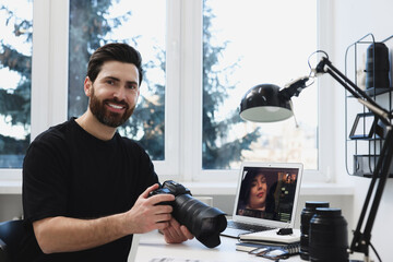 Professional photographer with digital camera at table in office