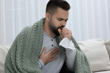 Sick man with tissue coughing at home
