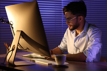 Tired young man working late in office