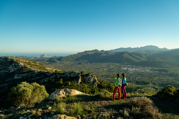 Obraz premium Two women hikers enjoying the beautiful nature from high above, Lliber, Alicante, Costa Blanca, Spain - stock photo