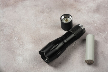 alkaline battery lie next to the flashlight. Symbol of clean energy. Eco friendly
