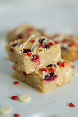 Blondie bars like brownies with white chocolate and raspberry home baking close up selective focus on light background