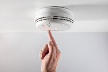 Home smoke and fire alarm detector checking, testing or replace battery - obrazy, fototapety, plakaty