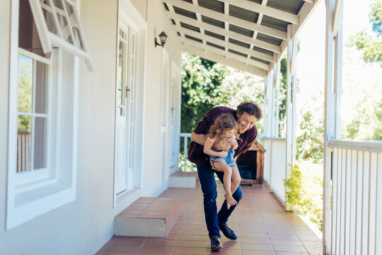 Father and daughter having fun on home porch