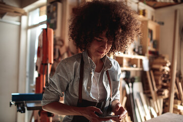 Woman listening to music in a woodworking workshop
