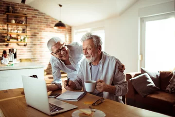 Poster Im Rahmen Senior couple using laptop at home © Vorda Berge