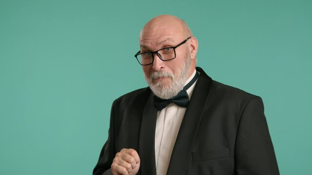 A senior man wearing a bowtie and suit displays a mischievous grin, hinting at a clever plan in mind, all portrayed against a light teal background. Camera 8K RAW. 