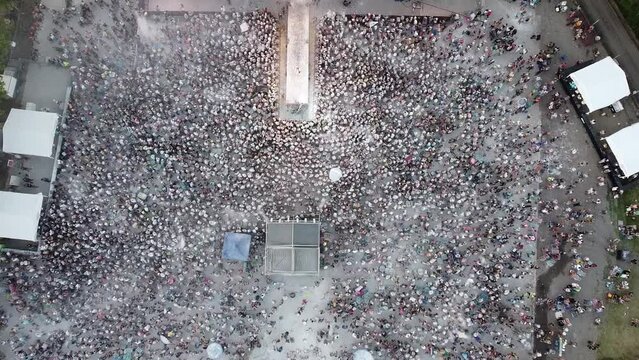 
Aerial panoramic view of a crowd of people participating in a popular carnival festival. People throwing flour at other people at the Chaya popular festival. Carnival celebrations in Argentina.