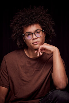 Studio portrait of young colored man with glasses on. Munich, Germany