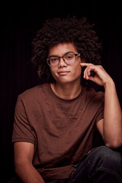 Studio portrait of young colored man with glasses on. Munich, Germany