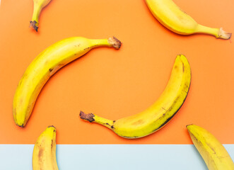 Bunches of ripe bananas on a multi-colored background. Knitting bananas. Top view