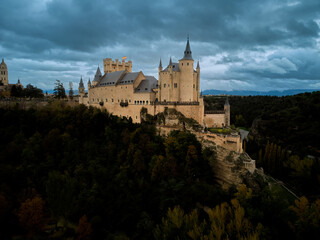 Obraz premium The Alcazar of Segovia a medieval castle with cloud sky and forest