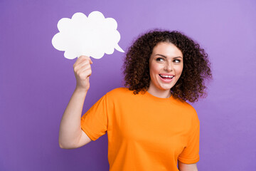 Photo of adorable excited woman wear orange t-shirt looking showing speaking bubble empty space isolated purple color background