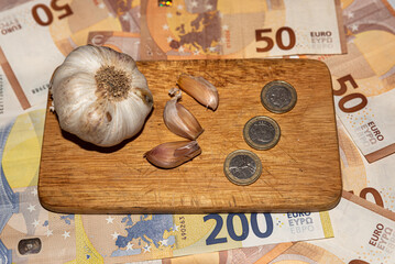 money in coin and garlic, spell for luck with banknotes background