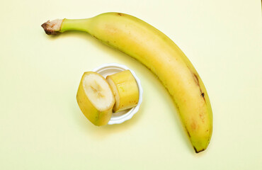 Sliced ​​Banana in peel on a yellow background. Fruit vitamin banana