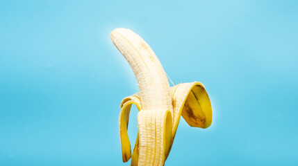 Ripe banana without peel on a blue background.