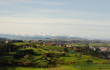 Obraz premium Cantabria, view inland over Liencres area, snow on Picos de Europa mountain range