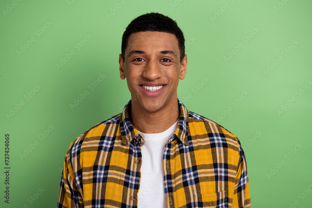 Sticker Portrait of toothy smiling handsome happy guy student wearing yellow plaid shirt white teeth model isolated on green color background