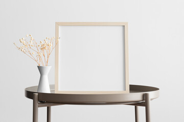 Wooden square frame mockup with a gypsophila decoration on the beige table.