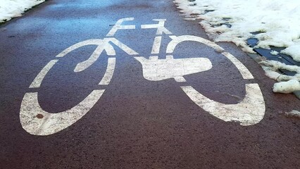 Bicycle path and snow. Road markings on bicycle lane. Winter sports, active leisure in snowy city. Beginning, opening of the cycling season