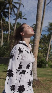 Young girl walking near palm trees in dress