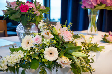 Beautiful arrangement of pink roses, lilies and African daisies for the top table at wedding ceremony