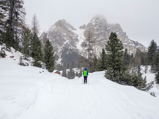 Fototapeta na wymiar snow falling on hiker in Fanes mountain Dolomites winter panorama landscape