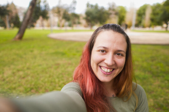Cheerful woman giving a peace sign while taking a selfie