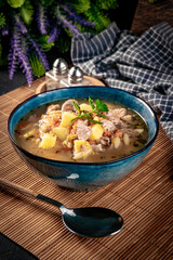 Pea soup with pieces of white sausage, potatoes and small dumplings.