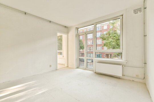 Bright empty room with large windows and urban view