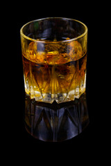 Glass of whiskey with ice on a black background