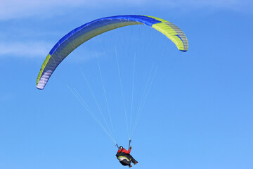 Paraglider flying in a blue sky	