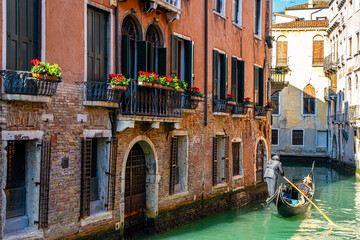 Gondolier navigating the canals of Venice - obrazy, fototapety, plakaty