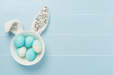 Blue easter eggs with bunny on wooden background, top view