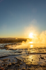 Stokkur geyser spectacular eruption in front of the sun , Iceland