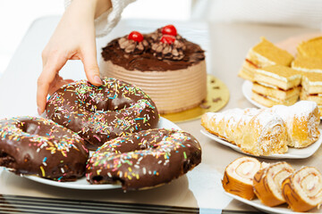 Lots of sweets on a table, variation of pastry products and donuts with chocolate, sugar addiction. Coffee bake and sweet snacks.