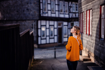 Contemplative Woman Walking in Historical European Village