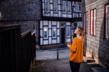 Contemplative Woman Walking in Historical European Village