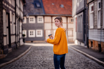 Casual Stroll with Coffee in Hand Through Cobblestoned Historical Street