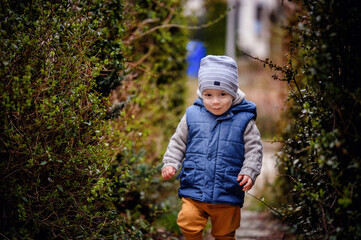 Cheerful Toddler Enjoying a Garden Walk in Warm Winter Clothes