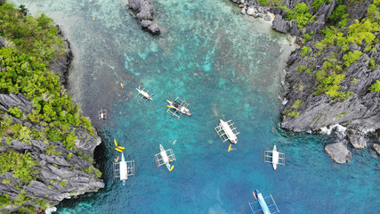 Wooden boats in karst mountains and blue lagoon aerial view
