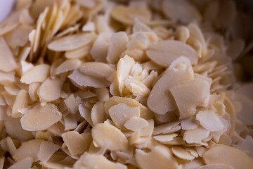 A closeup portrait of a lot of delicious almond flakes in it used by a baker to create tasty cookies or pastries. The chopped up crunchy cooking and baking ingredient is ready to be used.
